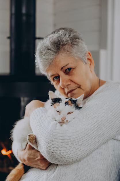 files/020124-bar-ukraine-60yearold-woman-wearing-white-warm-sweater-holds-yard-cat-her-arms-against-background-fireplace-white-house_632557-4316.avif
